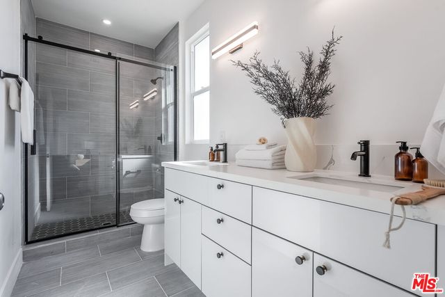 a bathroom with a double vanity sink toilet and shower