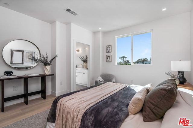 a bedroom with a bed a table and painting on the wall