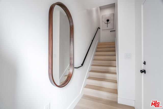 a view of staircase with railing and white walls