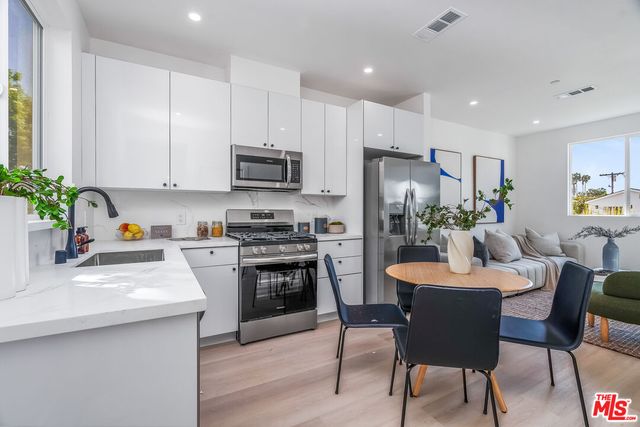 a kitchen with kitchen island granite countertop a sink stove and refrigerator