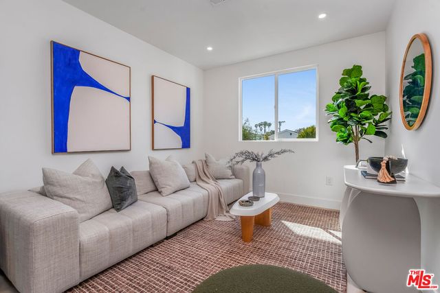 a living room with furniture a potted plant and a lamp