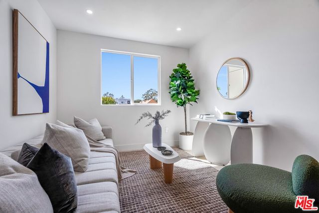 a living room with furniture a potted plant and a lamp