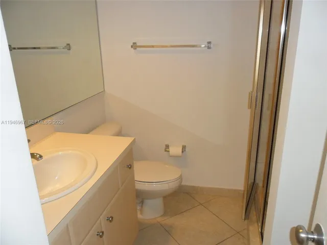 a bathroom with a granite countertop toilet and a sink