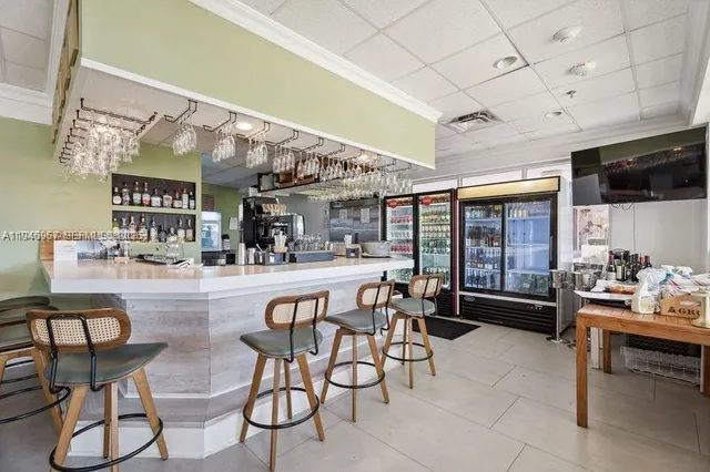 a kitchen with stainless steel appliances kitchen island granite countertop a table and chairs in it