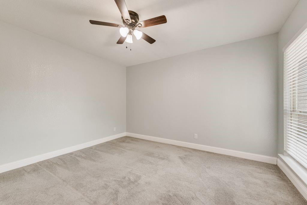 219 West Rochelle Road Irving, TX 75062 - Photo 26 of 29 Neutral-toned room featuring light gray walls, plush gray carpeting, and white baseboards