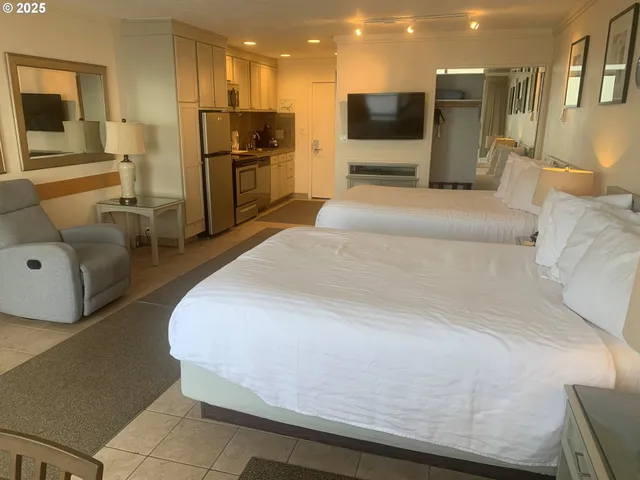 a large bedroom with a bed and a view of kitchen