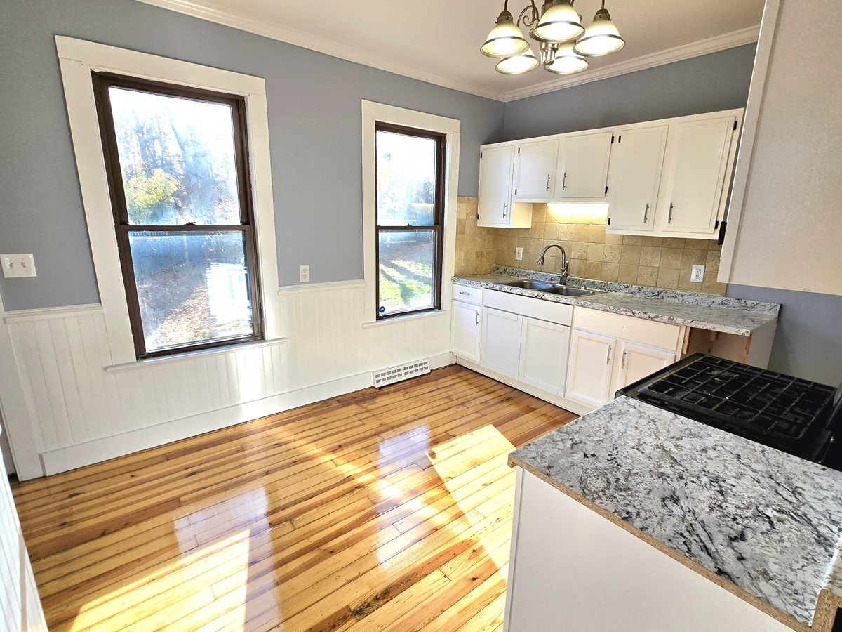 10 Clarkson Street Ansonia, CT 06401 - Photo 3 of 35 a kitchen with granite countertop a stove a sink and a window