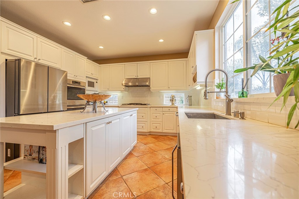 574 Oak Tree Court Simi Valley, CA 93065 - Photo 19 of 48 a large kitchen with stainless steel appliances lots of counter space and a sink