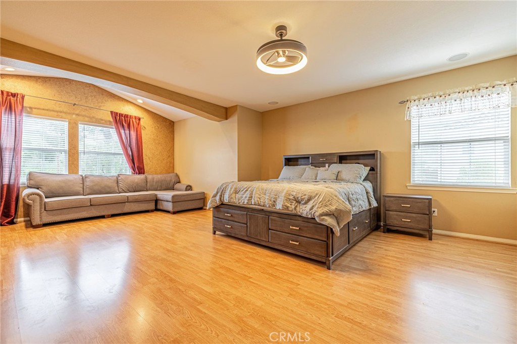 574 Oak Tree Court Simi Valley, CA 93065 - Photo 35 of 48 a spacious bedroom with a bed a couch and dresser next to a window