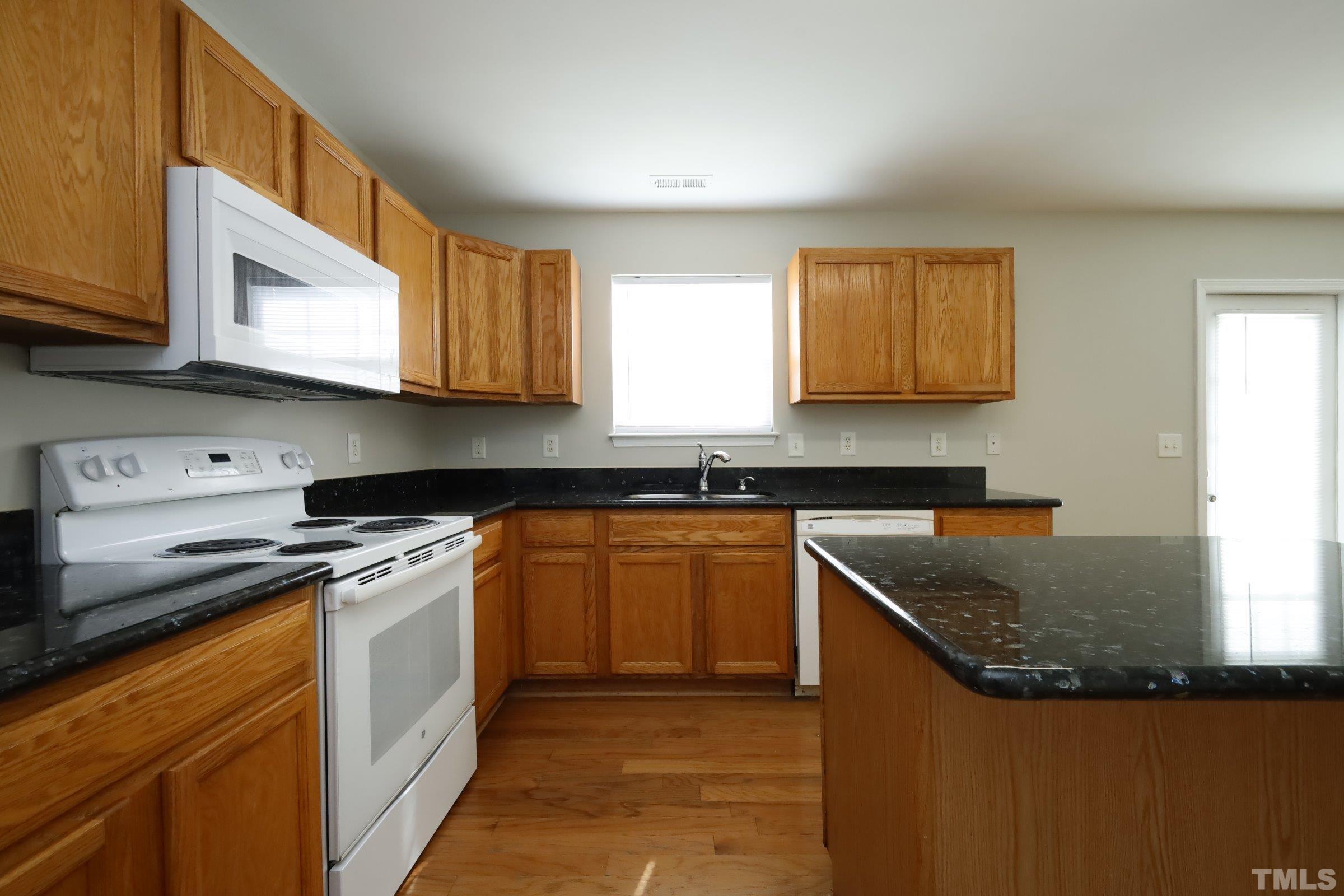 4014 Springfield Creek Drive Raleigh, NC 27616 - Photo 12 of 36 a kitchen with stainless steel appliances granite countertop a sink stove and microwave