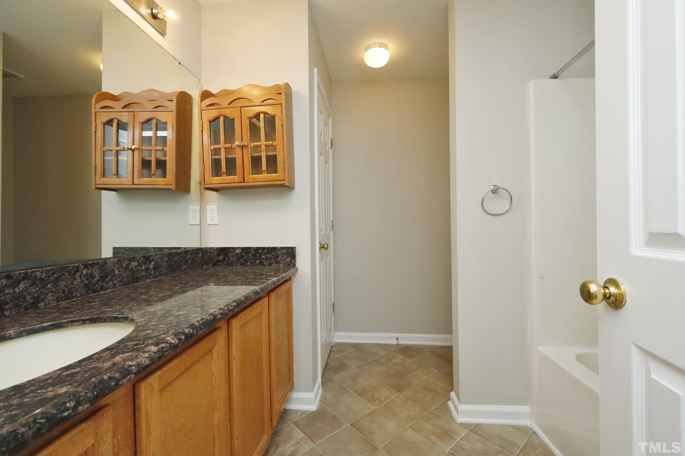 4014 Springfield Creek Drive Raleigh, NC 27616 - Photo 21 of 36 a bathroom with a granite countertop sink and a mirror