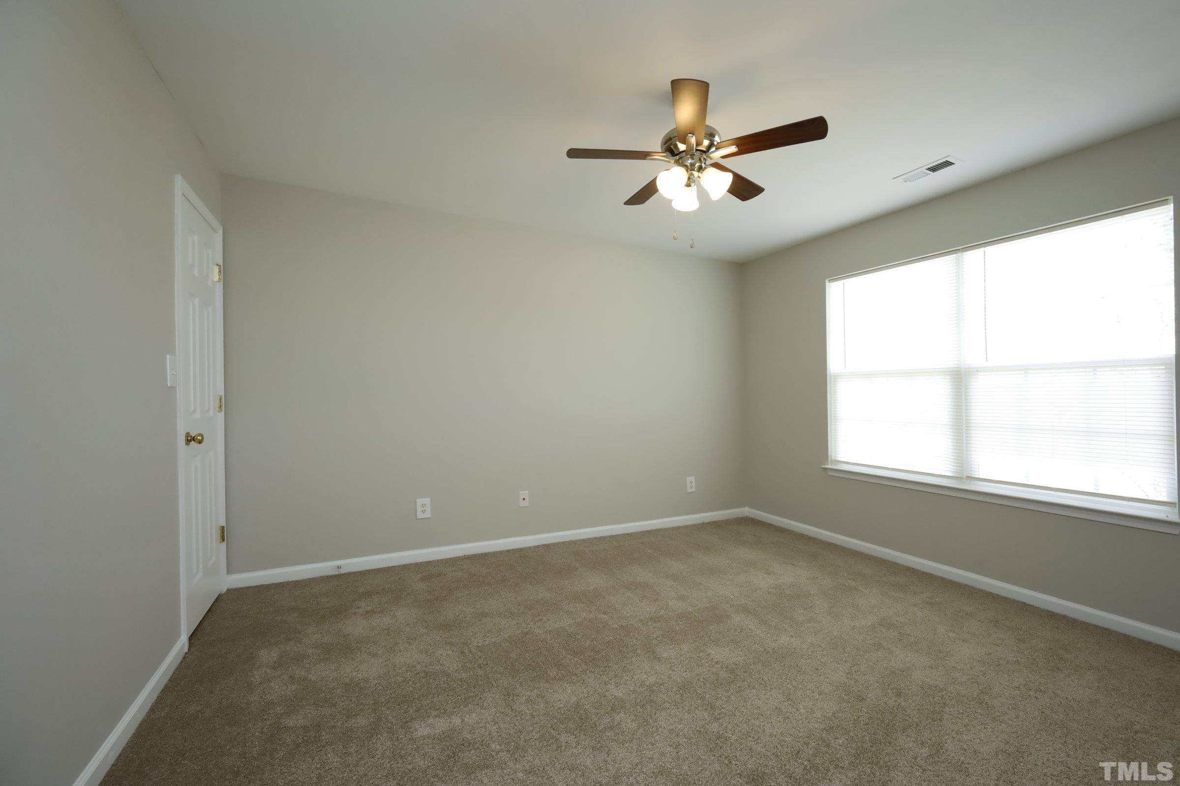 4014 Springfield Creek Drive Raleigh, NC 27616 - Photo 24 of 36 an empty room with windows and fan