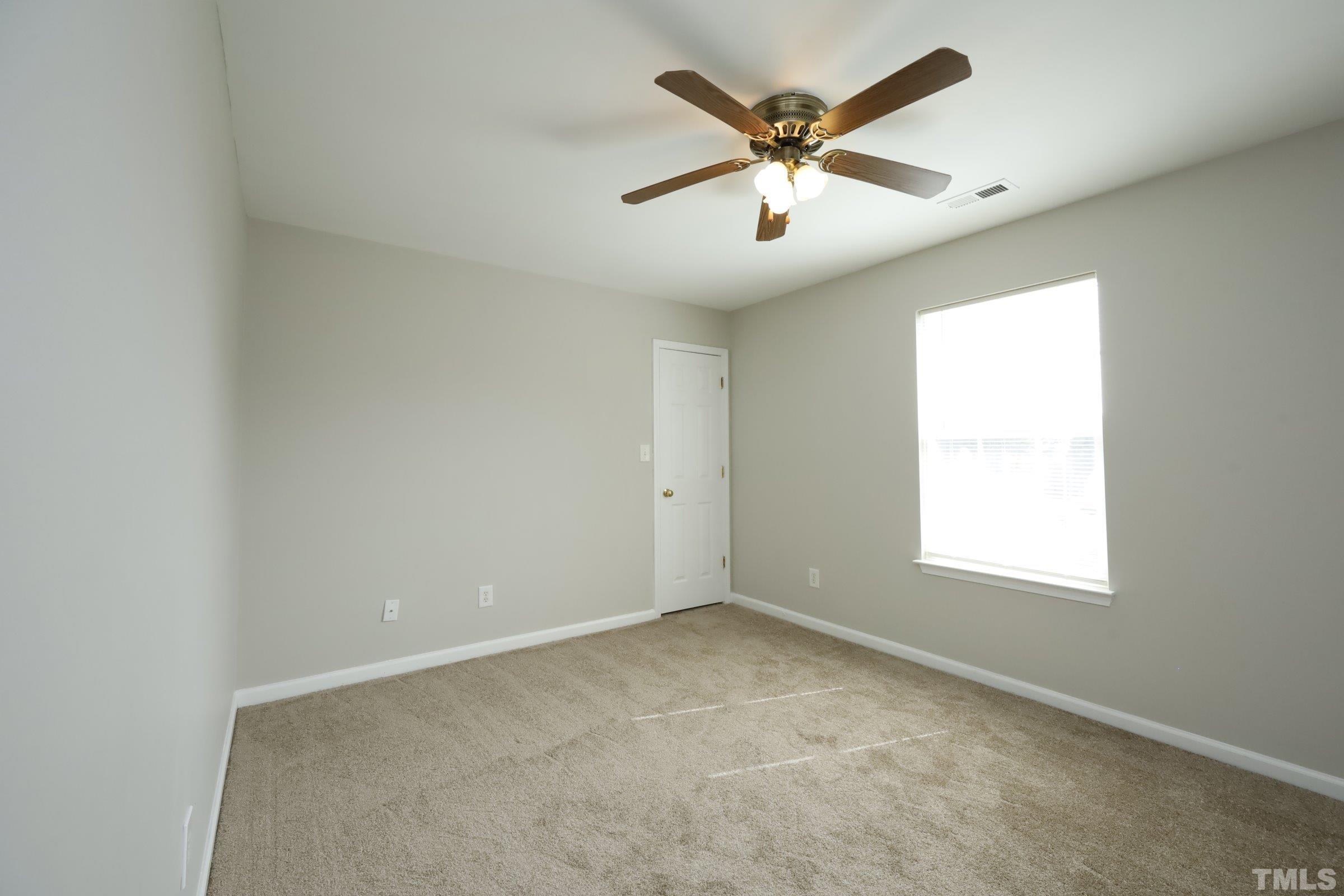 4014 Springfield Creek Drive Raleigh, NC 27616 - Photo 25 of 36 an empty room with a window and a fan