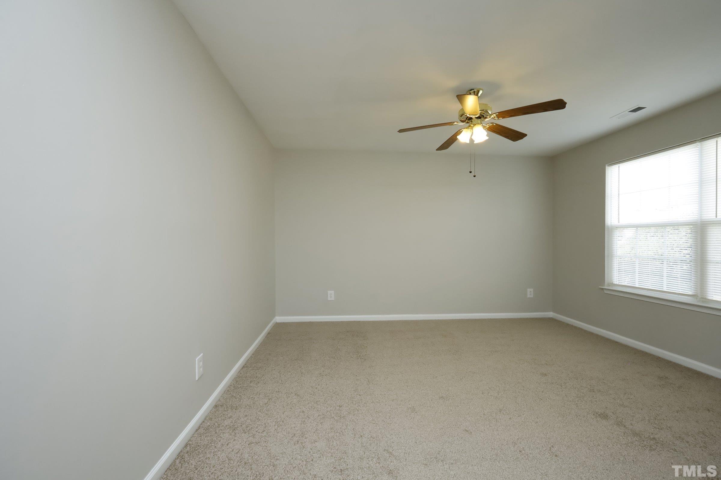 4014 Springfield Creek Drive Raleigh, NC 27616 - Photo 4 of 36 an empty room with a window and a fan