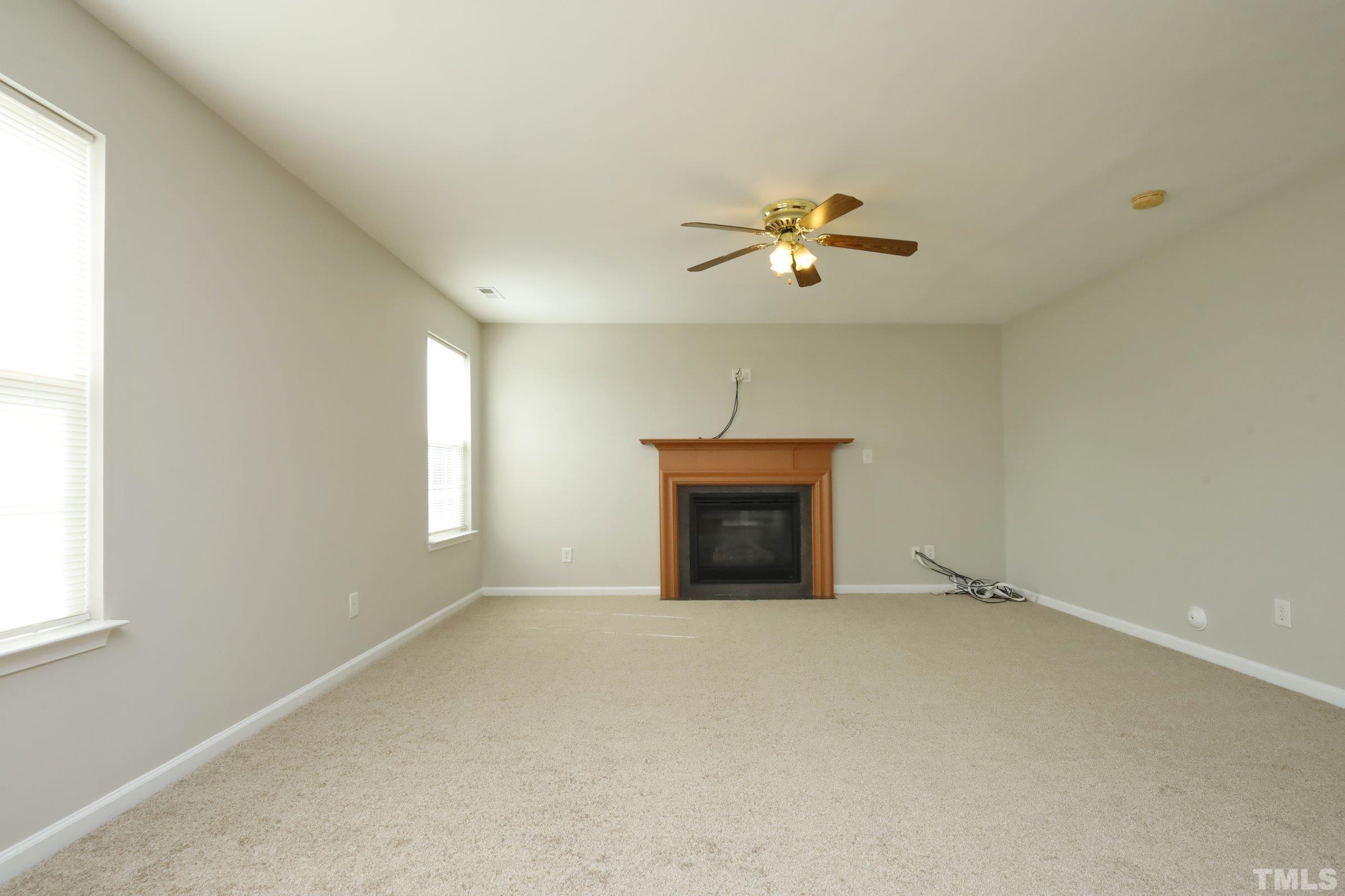 4014 Springfield Creek Drive Raleigh, NC 27616 - Photo 6 of 36 an empty room with chandelier fan and windows