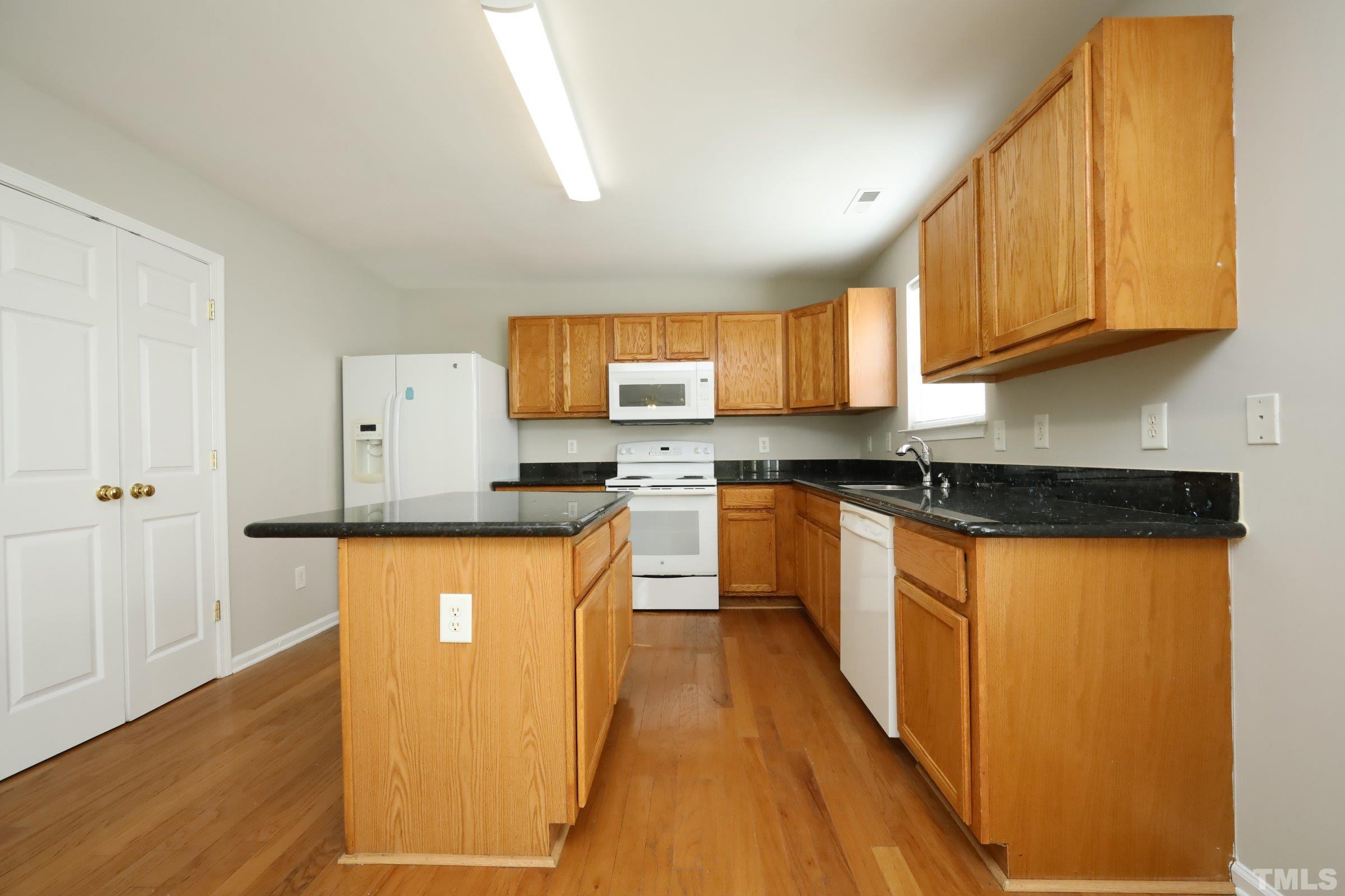 4014 Springfield Creek Drive Raleigh, NC 27616 - Photo 10 of 36 a kitchen with stainless steel appliances granite countertop a stove a sink and a refrigerator