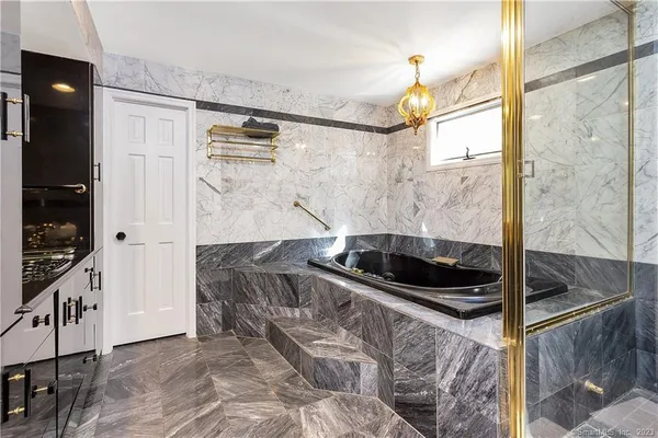 a bathroom with a granite countertop sink a mirror and shower