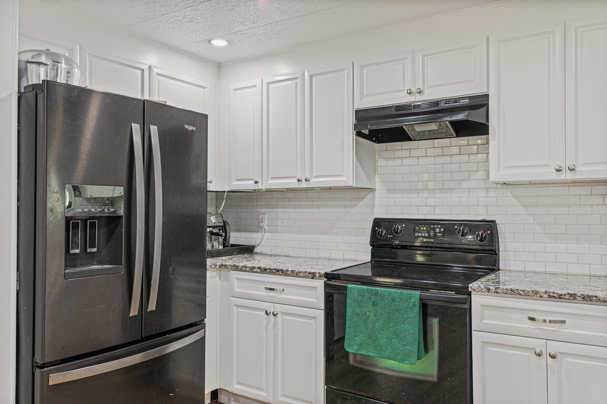 963 Catalina Road St. Augustine, FL 32086 - Photo 18 of 59 a kitchen with stainless steel appliances granite countertop a refrigerator a stove and white cabinets