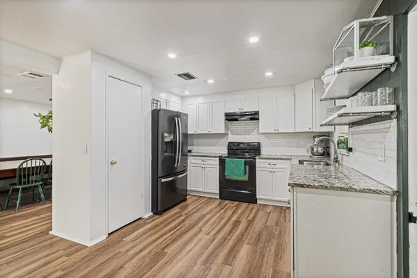 a kitchen with refrigerator and cabinets