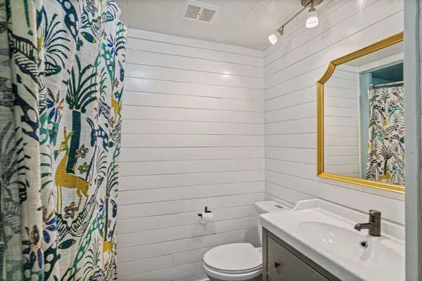 a bathroom with a toilet sink and mirror