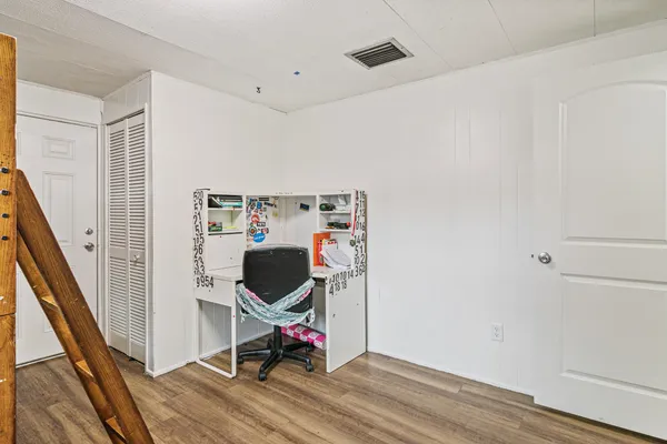 a view of a room with wooden floor and furniture