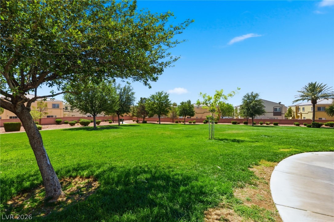 6312 Sandy Ridge Street, Unit 3102 North Las Vegas, NV 89081 - Photo 27 of 31 A vibrant green lawn and well-maintained shrubs create a peaceful outdoor environment.