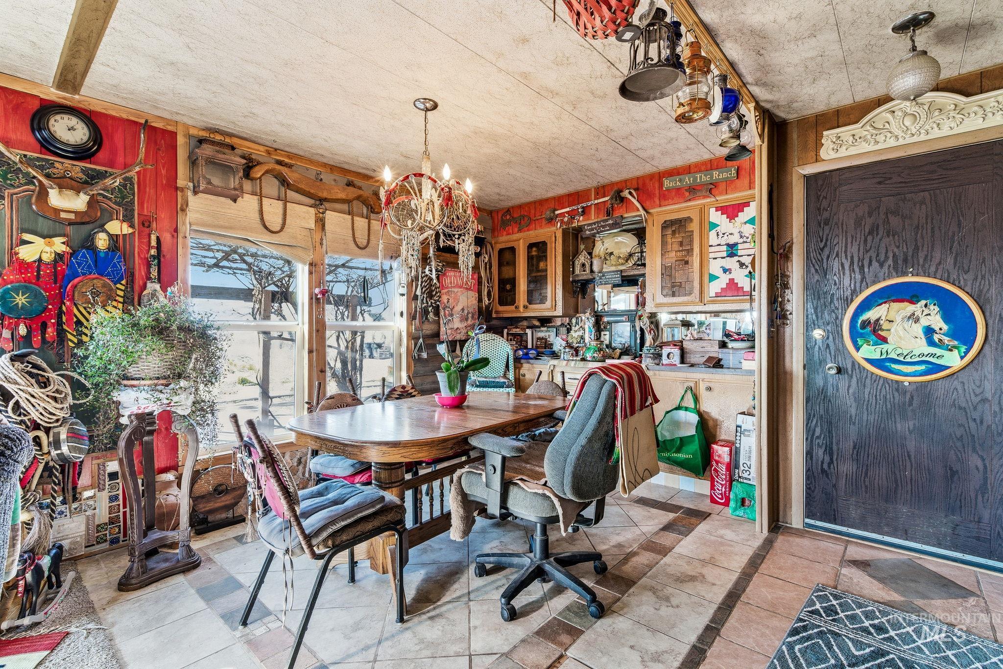 603 East King Road Kuna, ID 83634 - Photo 14 of 22 Dining area with inlaid floor details, wooden walls, a chandelier, and light tile patterned floors
