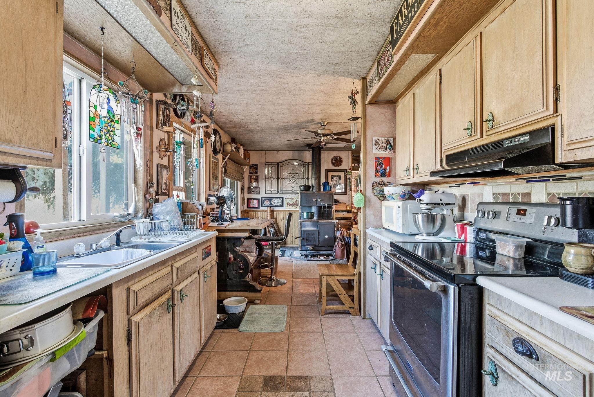 603 East King Road Kuna, ID 83634 - Photo 16 of 22 Kitchen with light brown cabinetry, stainless steel range with electric cooktop, light countertops, and a ceiling fan