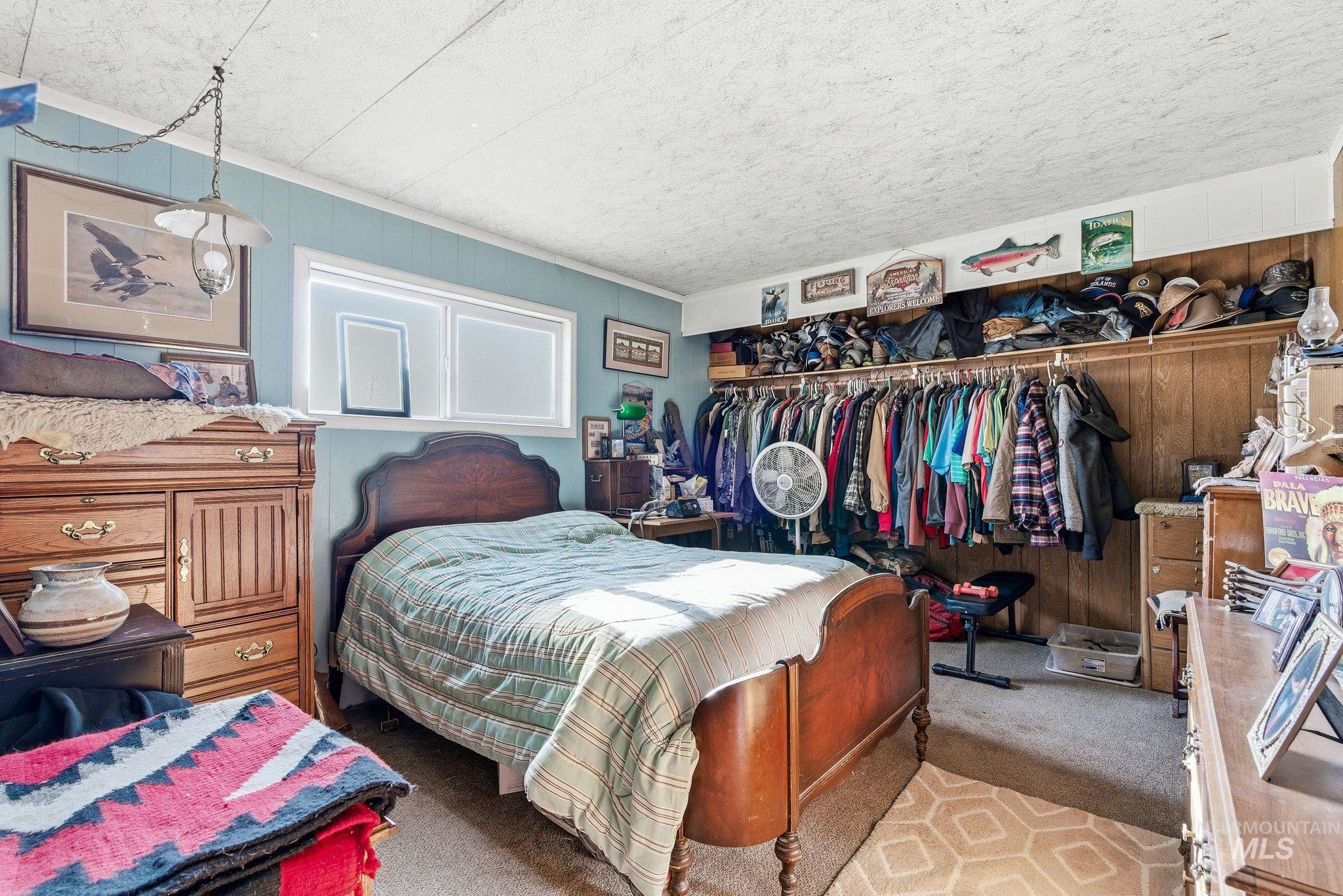 603 East King Road Kuna, ID 83634 - Photo 18 of 22 Carpeted bedroom with wood walls, a closet, and ornamental molding