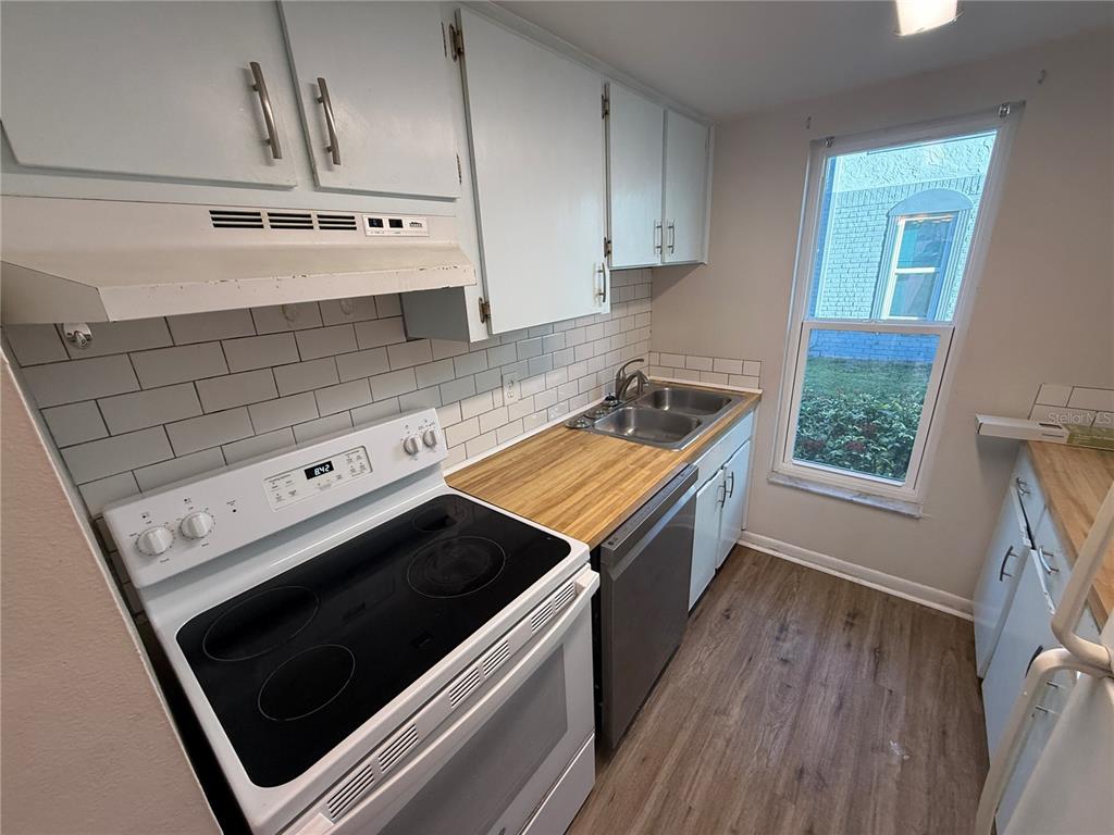 5120 East Temple Heights Road, Unit D Tampa, FL 33617 - Photo 4 of 14 a kitchen with stainless steel appliances a stove a microwave and cabinets