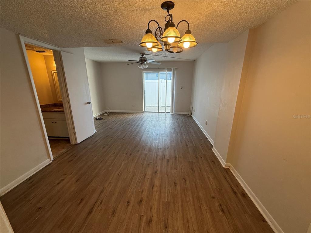 5120 East Temple Heights Road, Unit D Tampa, FL 33617 - Photo 6 of 14 a view of a room with wooden floor and chandelier