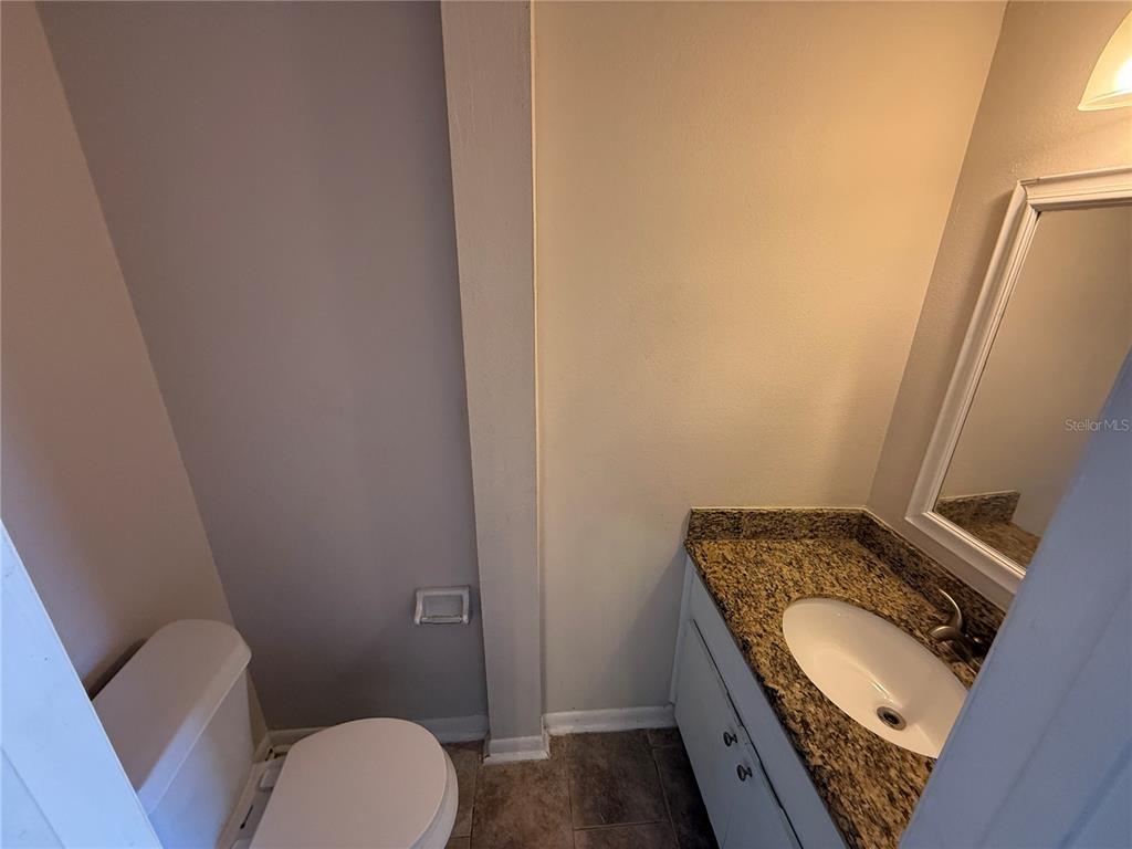 5120 East Temple Heights Road, Unit D Tampa, FL 33617 - Photo 8 of 14 a bathroom with a granite countertop toilet sink and mirror
