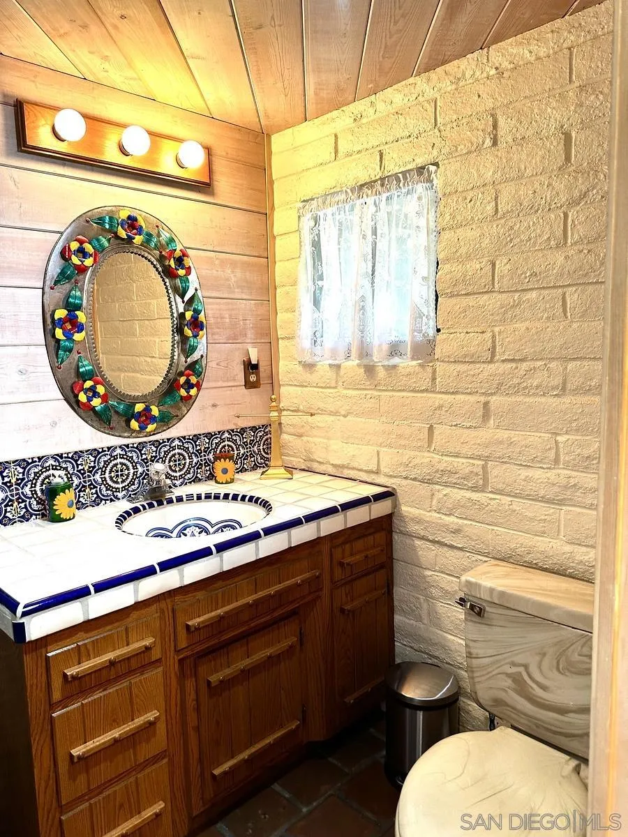 23684 Viejas Grade Road Descanso, CA 91916 - Photo 32 of 54 a bathroom with a toilet sink vanity and mirror