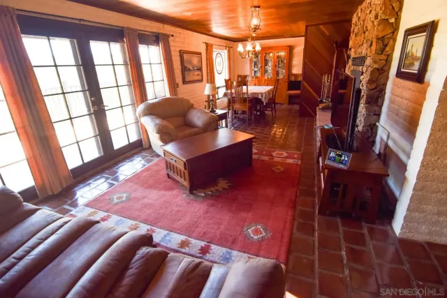 a living room with furniture a rug and a floor to ceiling window