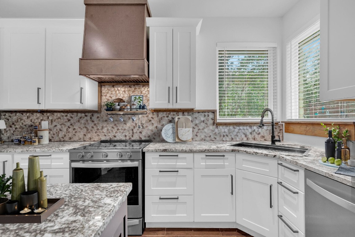 326 Coventry Road Spicewood, TX 78669 - Photo 11 of 30 a kitchen with granite countertop a sink stainless steel appliances and cabinets