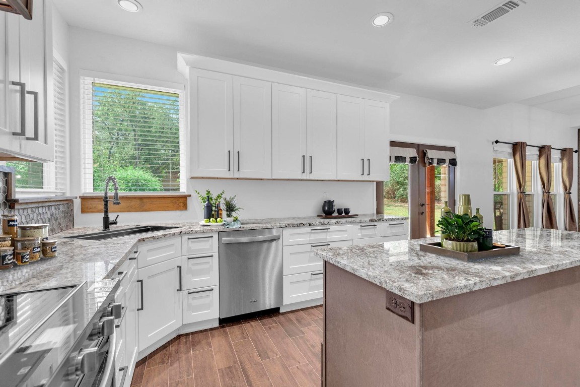 326 Coventry Road Spicewood, TX 78669 - Photo 12 of 30 a kitchen with granite countertop sink stove and cabinets