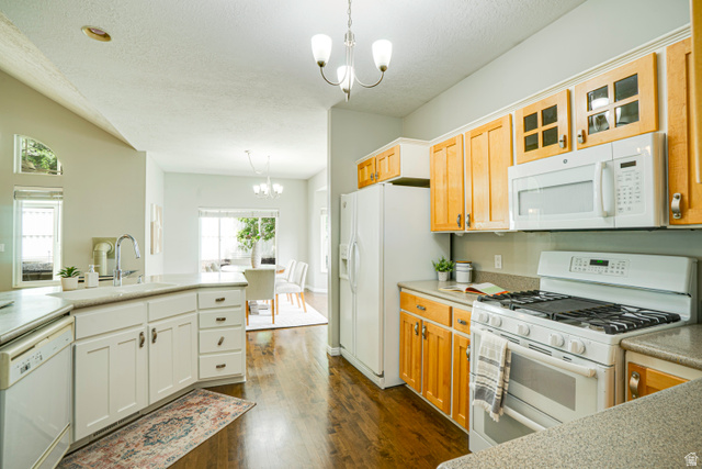 1433 Forge Way Draper, UT 84020 - Photo 12 of 29 Kitchen featuring wood-finish flooring, white cabinetry, a double basin sink, and an integrated dishwasher