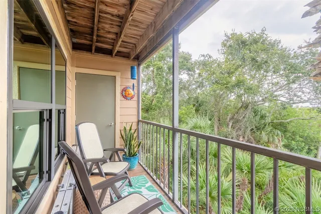 a view of a balcony with chair and wooden floor