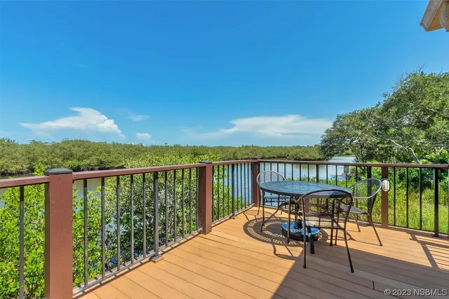 a view of a balcony with wooden floor and outdoor seating