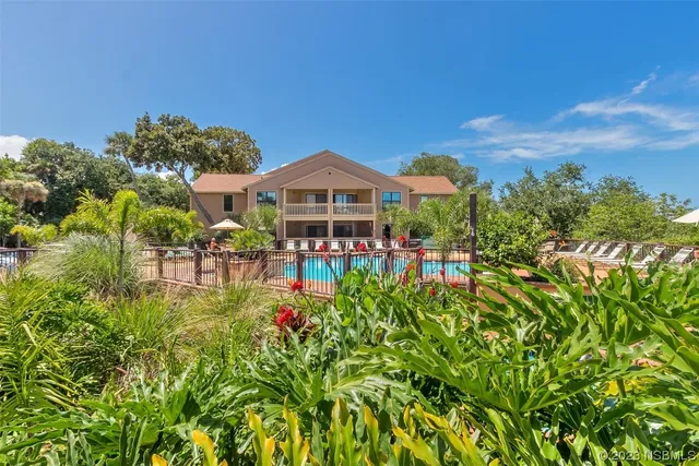 a front view of a house with a yard and fountain