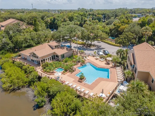an aerial view of a house with a garden and lake view