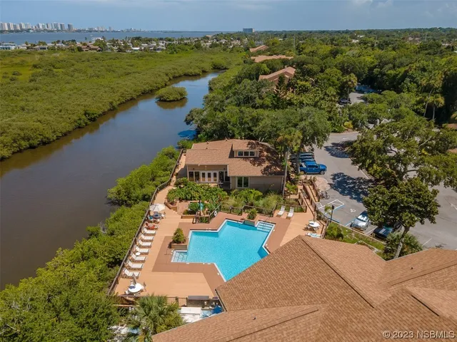 an aerial view of a house with a yard and lake view