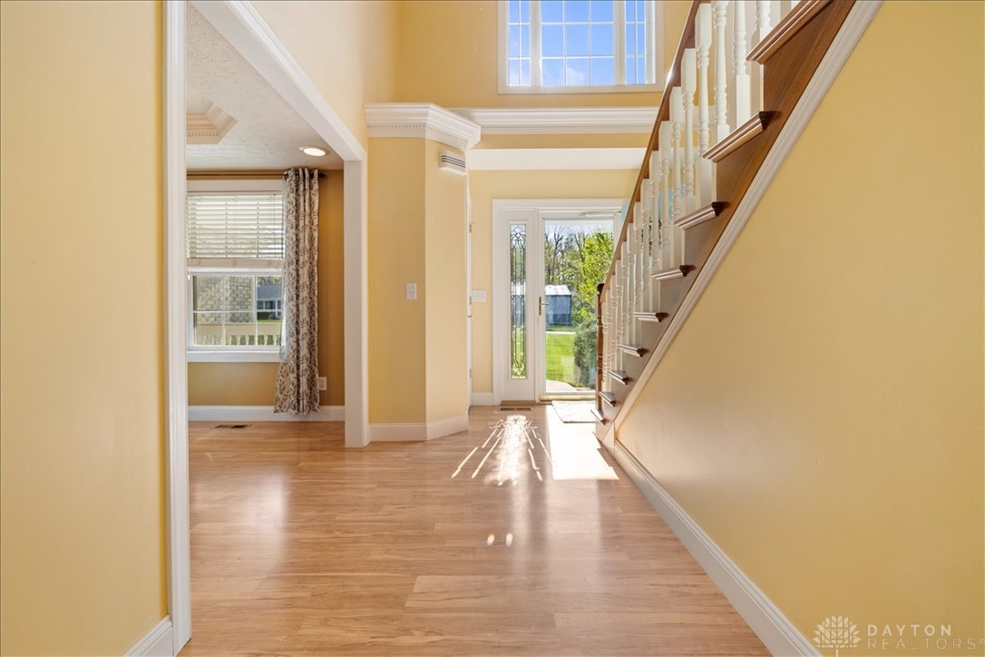 841 Willow Road Springfield, OH 45502 - Photo 4 of 64 This entry hall features warm lighting and a grand staircase, creating a welcoming and elegant first impression.