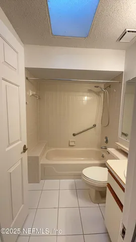 a bathroom with a granite countertop sink a toilet and bathtub