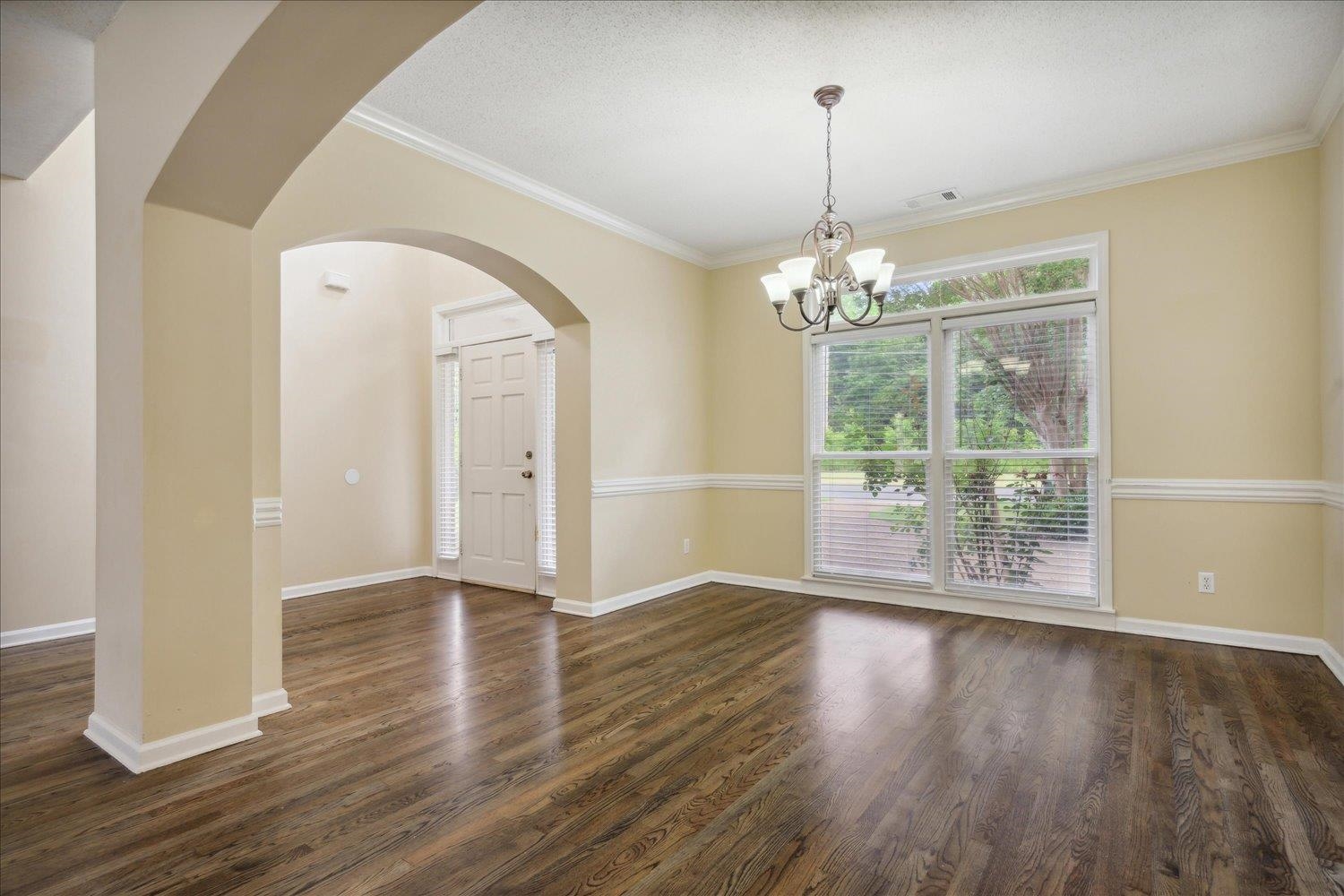 8817 Dexter Road Memphis, TN 38016 - Photo 6 of 34 Unfurnished room with crown molding, dark hardwood / wood-style floors, and an inviting chandelier