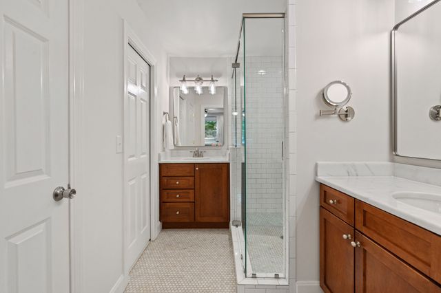 a bathroom with a granite countertop sink a mirror and shower