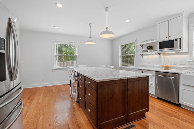 a kitchen with granite countertop a stove and a wooden floors