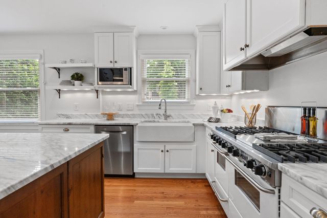 a kitchen with stainless steel appliances granite countertop a sink stove and cabinets