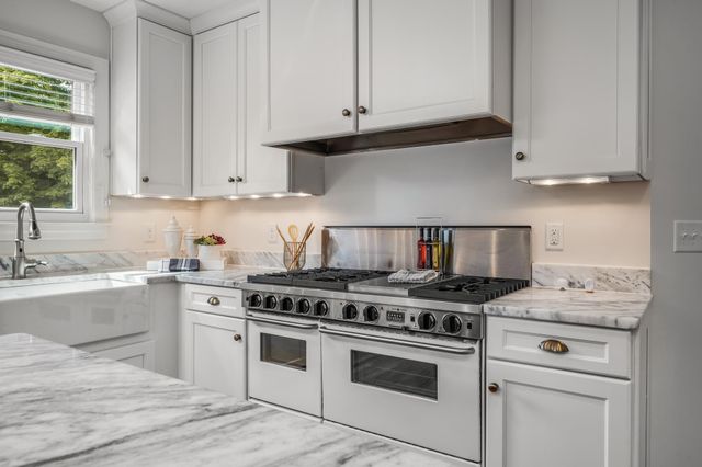 a kitchen with granite countertop white cabinets and white appliances