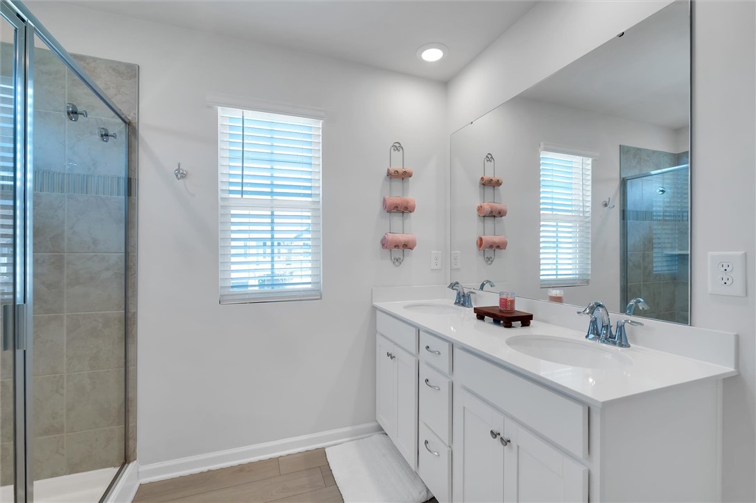 453 Bee Cv Way Pendleton, SC 29670 - Photo 15 of 25 A well-lit primary bathroom features a spacious shower and a vanity with dual sinks, offering both style and functionality.